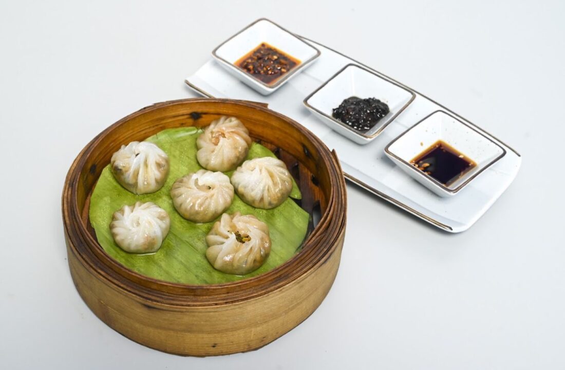 Steamed dimsum in a bamboo basket with three sauces at Nouba Restaurant and Rooftop Lounge, C-Scheme Jaipur