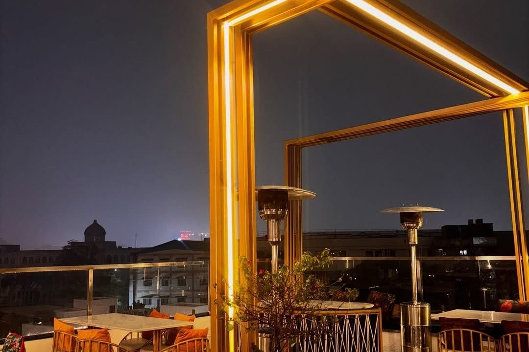 Rooftop terrace at night with gold framework at Nouba Restaurant and Rooftop Lounge, C-Scheme Jaipur