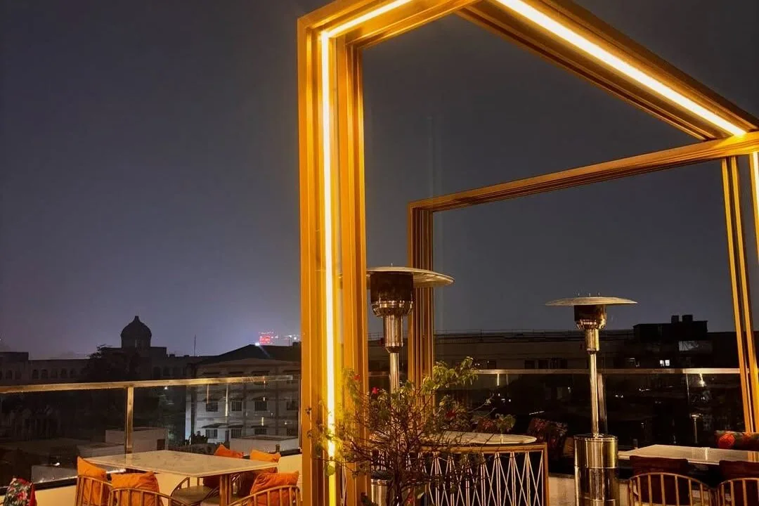 Rooftop terrace at night with gold framework at Nouba Restaurant and Rooftop Lounge, C-Scheme Jaipur