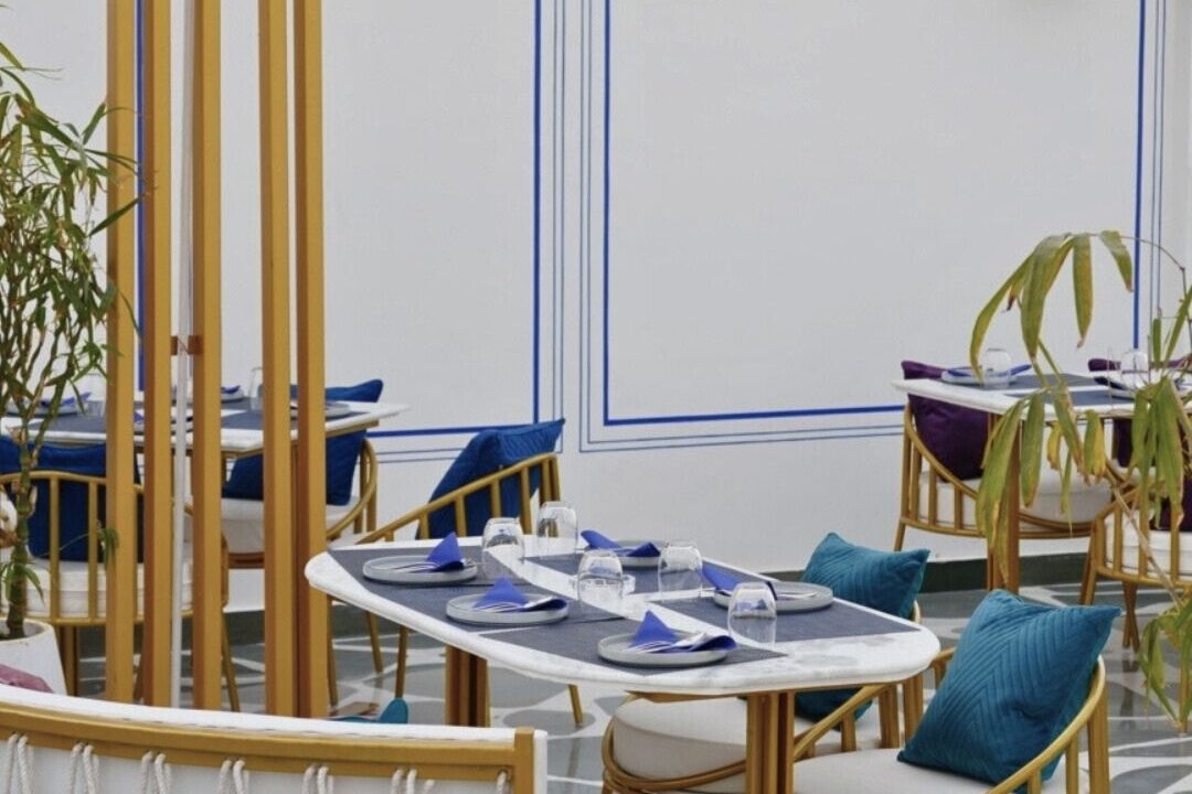 Interior seating beside a window at Nouba Restaurant and Rooftop Lounge, C-Scheme Jaipur