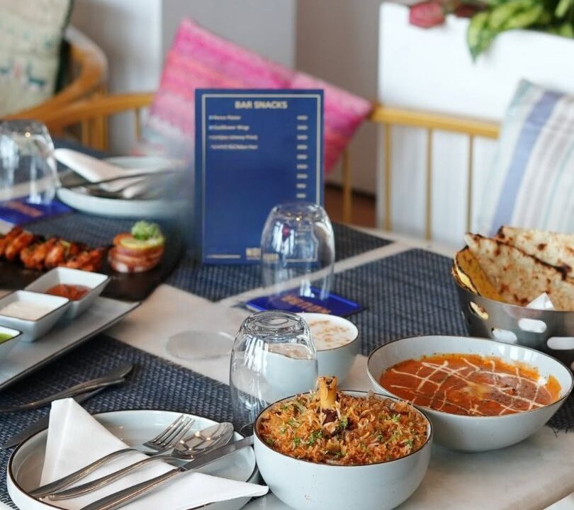 Laid table setting with menu and glassware at Nouba Restaurant and Rooftop Lounge, C-Scheme Jaipur
