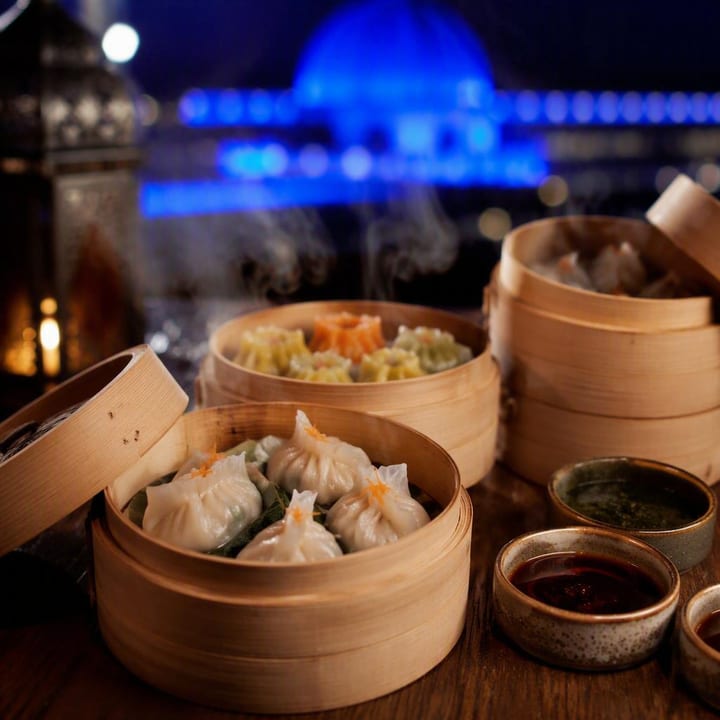 Steaming bamboo baskets of dim sum on a table with chopsticks at Nouba Restaurant and Rooftop Lounge, C-Scheme Jaipur