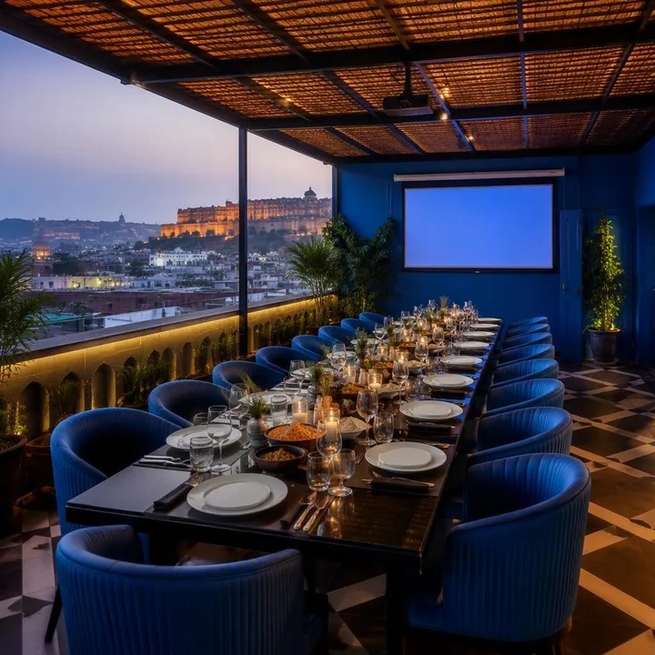 Rooftop table setup with AV screen and projector facing group seating at Nouba Restaurant and Rooftop Lounge, C-Scheme Jaipur
