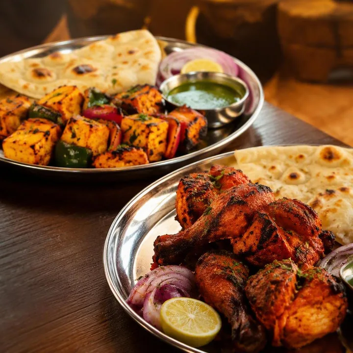 Mixed vegetarian and non-vegetarian dishes on sharing platters at Nouba Restaurant and Rooftop Lounge, C-Scheme Jaipur