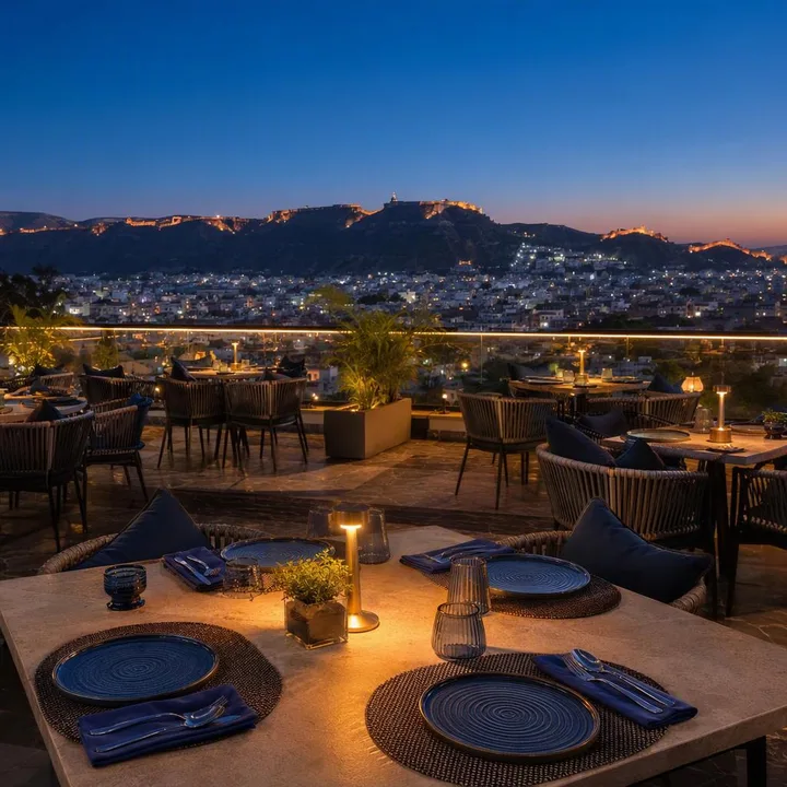 Electric blue rooftop tables with Jaipur skyline at dusk at Nouba Restaurant and Rooftop Lounge, C-Scheme Jaipur