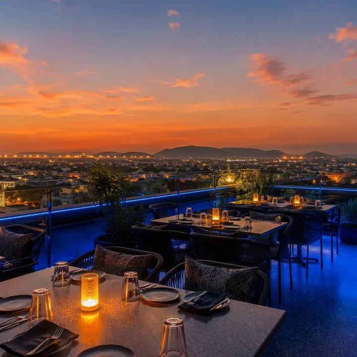 Rooftop tables with Jaipur skyline view at sunset at Nouba Restaurant and Rooftop Lounge, C-Scheme Jaipur
