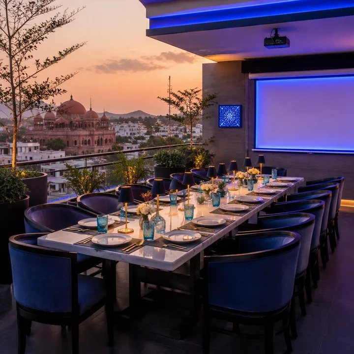 Rooftop table setup with AV screen and Jaipur skyline view at dusk at Nouba Restaurant and Rooftop Lounge, C-Scheme Jaipur