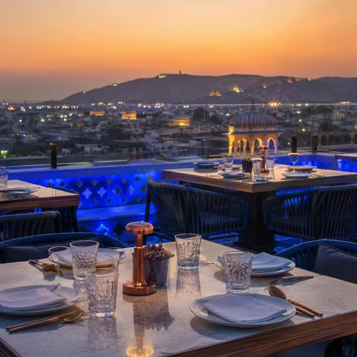 Rooftop tables set for corporate group dinner with skyline view at Nouba Restaurant and Rooftop Lounge, C-Scheme Jaipur