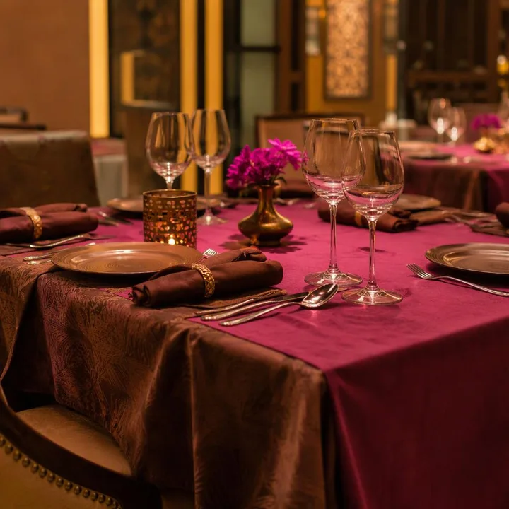 Indoor dining tables with brown and magenta decor on 3rd floor at Nouba Restaurant and Rooftop Lounge, C-Scheme Jaipur