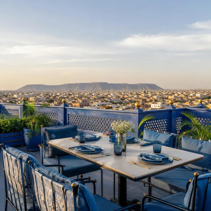 4th floor rooftop table with Jaipur skyline view in afternoon light at Nouba Restaurant and Rooftop Lounge, C-Scheme Jaipur