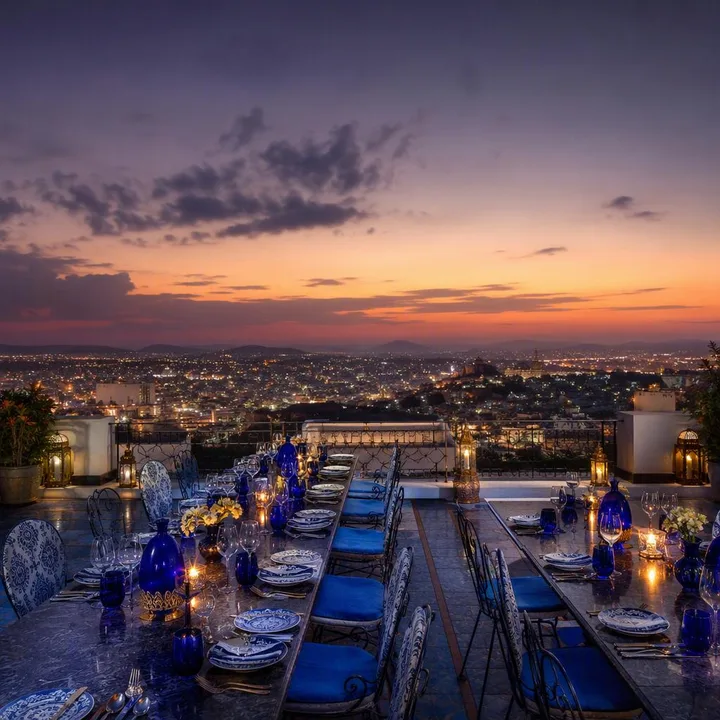 Rooftop tables set for large group dining with Jaipur skyline view at Nouba Restaurant and Rooftop Lounge, C-Scheme Jaipur