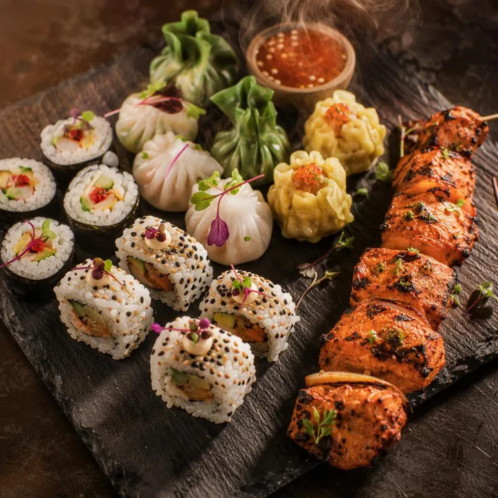 Maki and uramaki rolls on plate with dim sum and tandoor skewers beside at Nouba Restaurant and Rooftop Lounge, C-Scheme Jaipur