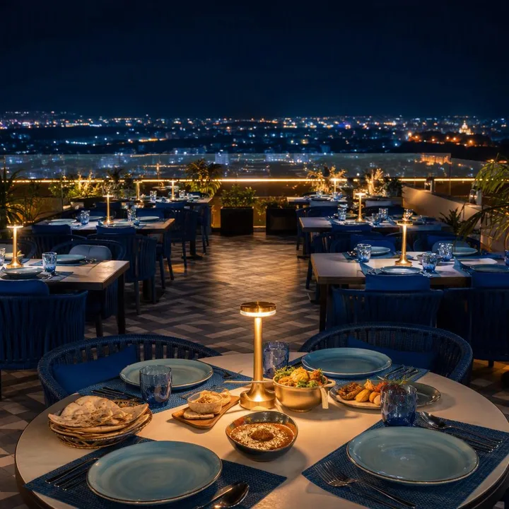 Rooftop table setup with skyline view at night at Nouba Restaurant and Rooftop Lounge, C-Scheme Jaipur