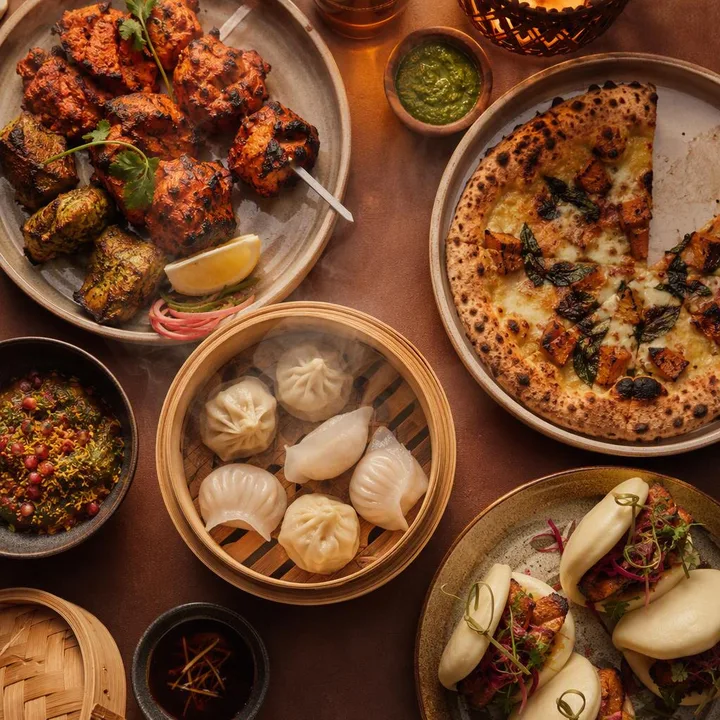 Family style shared plates from three kitchens on a table at Nouba Restaurant and Rooftop Lounge, C-Scheme Jaipur