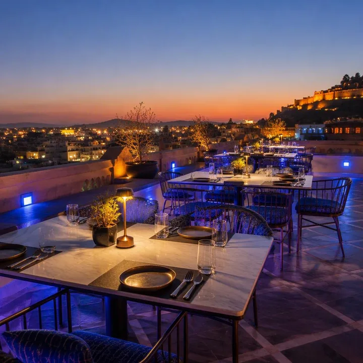 Rooftop tables set for group dinner with skyline view at Nouba Restaurant and Rooftop Lounge, C-Scheme Jaipur