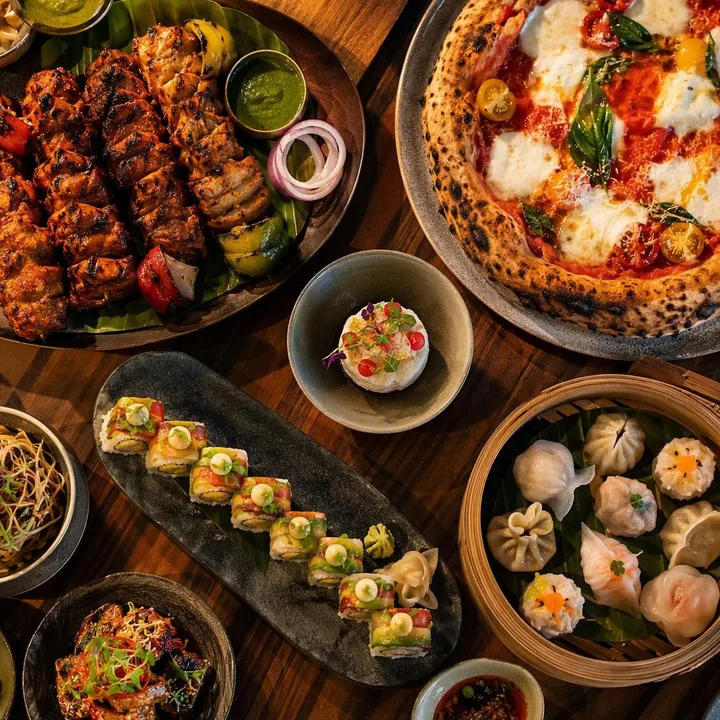 Set menu platters with tandoor items pizza and Pan-Asian dishes on table at Nouba Restaurant and Rooftop Lounge, C-Scheme Jaipur