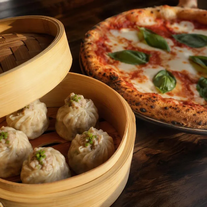 Steaming dim sum basket with chopsticks beside a slice of wood-fired pizza at Nouba Restaurant and Rooftop Lounge, C-Scheme Jaipur