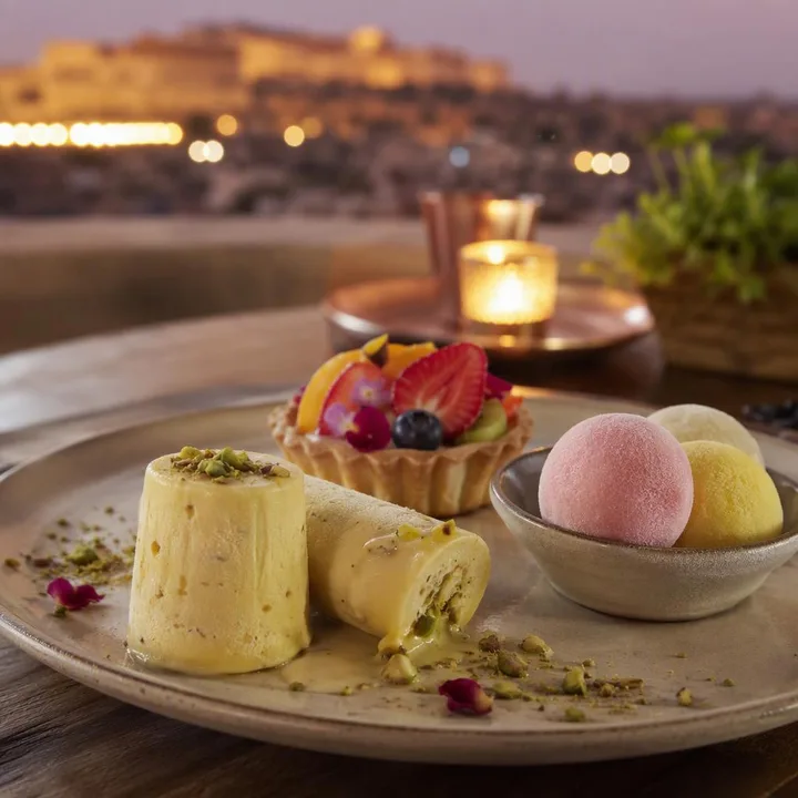 Signature dessert plate with Indian sweets and fruit garnishes at Nouba Restaurant and Rooftop Lounge, C-Scheme Jaipur