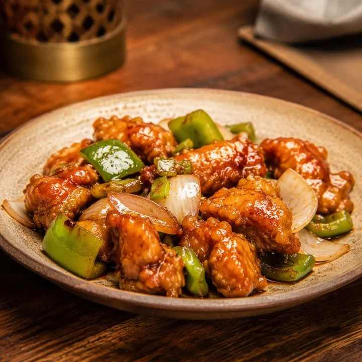Plate of mild chilli chicken with vegetables at Nouba Restaurant and Rooftop Lounge, C-Scheme Jaipur