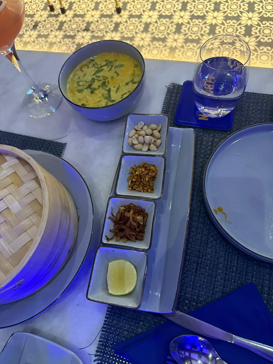 Khow suey bowl with condiments at Nouba Jaipur